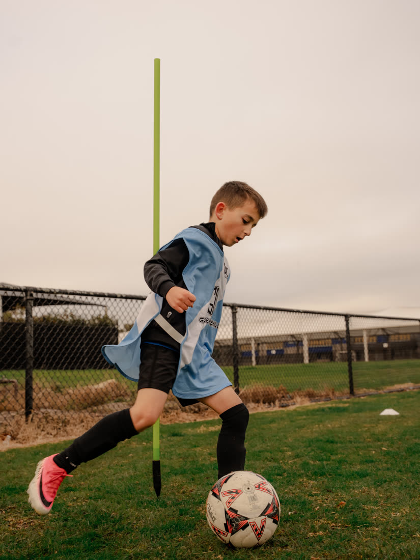 A player dribbling through practice poles
